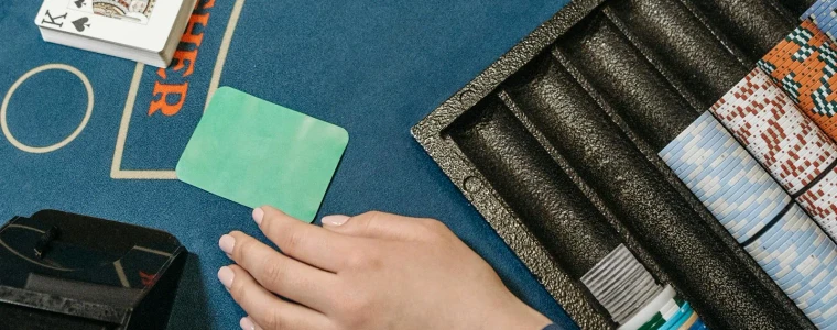 Bàn Blackjack nỉ xanh với lá Át và lá K tạo thành 21 cùng vài chồng chip cược minh họa cho bài hướng dẫn luật chơi
